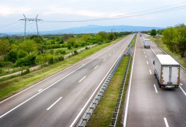 Büyük Ulaşım Kamyonları kırsal kesimden geçen bir otoyoldan yola çıkıyor.