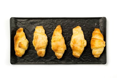 Siyah tabak ve beyaz arka planda servis edilen Kiflice adı verilen geleneksel rulo hamur.