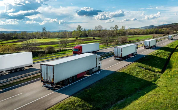 美しい青空の下 田園地帯の高速道路を通る線での輸送トラックの輸送 ストックフォト