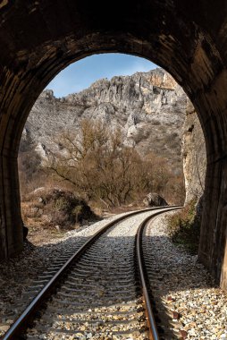 Resimli kırsal manzaradaki kısa tünellerden geçen eski demiryolu.