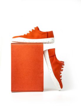 Bir çift Stylis Yeni Kırmızı Spor Ayakkabı ve beyaz arka planda izole edilmiş kırmızı kutu. Kırmızı tenis ayakkabıları