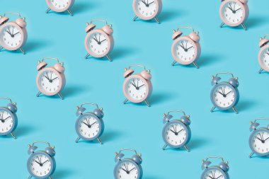 Parlak mavi arkaplanda pembe ve mavi alarm saatleriyle yapılan moda desen