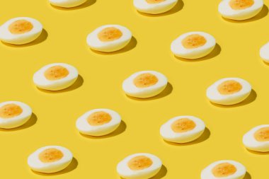 Haşlanmış yumurta, parlak sarı bir arka planda ikiye bölünmüş, modaya uygun modern yemek sanatı.