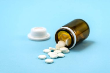 İlaç şişesinden dökülen beyaz ilaç hapları ve haplar. Kopyalama alanı olan yukarıdan aşağıya görünüm.