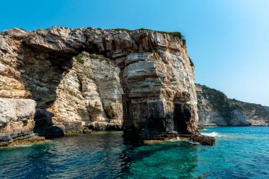 Blue Sky ve Turkuaz Water ile Denizde Rock Cliff Sahnesi. Yunanistan 'daki Antipaxos Adası' nda Güzel Gün.