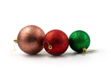 Üç Noel topu (küreler), beyaz üzerine izole edilmiş pembe, kırmızı ve yeşil toplar