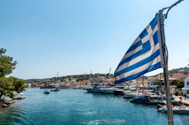Gaios, Yunanistan - 20 Ağustos 2023. Yunanistan 'ın Paxos adasının başkenti olan Gaios limanı, Yunanistan' ın Korfu adası yakınlarında Yunan bayrağı görünüyor