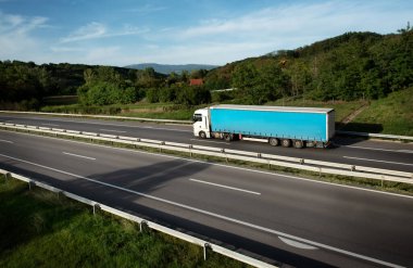 Gün batımında yarı karavanlı bir kamyon otoban boyunca gidiyor. Yoldan mal teslimatı. Hizmet ve Ulaştırma Lojistiği. Modern Lorry Taşımacılık. Uzun kendi kendine giden kamyonlar.