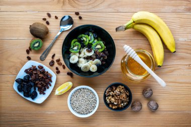 Sağlıklı kahvaltı. Sırılsıklam organik arpa, ceviz, kivi, muz, kuru üzüm, kuru erik ve bal.