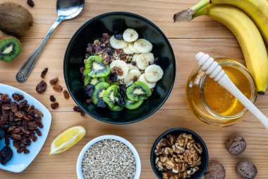 Sağlıklı kahvaltı. Sırılsıklam organik arpa, ceviz, kivi, muz, kuru üzüm, kuru erik ve bal.