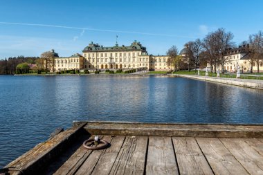 Stockholm yakınlarındaki Drottningholm Sarayı, İsveç 'in güzel güneşli bir günde gölü olan kraliyet sarayı manzarası