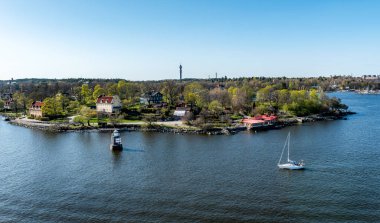 Stockholm 'ün dışındaki İsveç takımadalarında küçük cennet limanı. Sonbahar akşamı güneş lekesi ile aydınlanan güzel bir yansıması var..
