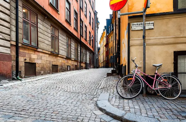 Stockholm 'ün en eski mahallesi olan Gamla Stan' deki İsveç kaldırım taşı caddesi. Park halindeki bisikletler renkli alçı binalara yaslanıyor.