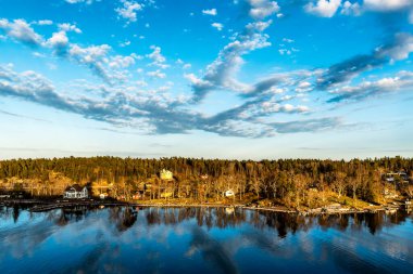 Stockholm takımadalarındaki güzel güneşli bir gün batımında adaların manzarası. İsveç. Su manzarası