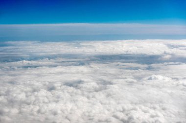 Beyaz kümülüs bulutları açık mavi gökyüzü arka planında, kapalı gökyüzü fon, yumuşak bulut dokusu, güzel güneşli bulutlu manzara cenneti. Uçaktan beyaz bulutlar görünüyor