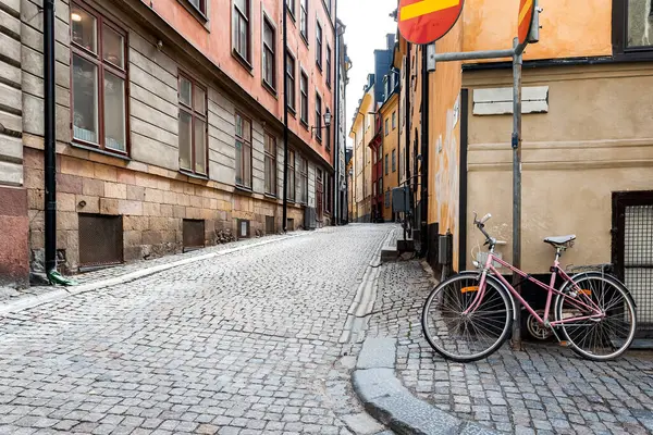 Stockholm 'ün en eski mahallesi olan Gamla Stan' deki İsveç kaldırım taşı caddesi. Park halindeki bisikletler renkli alçı binalara yaslanıyor.