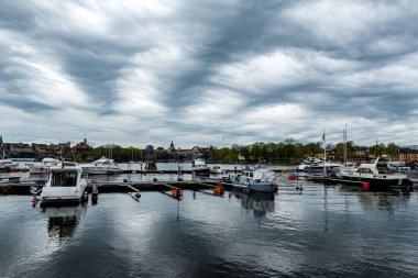 Fırtınadan önce güzel dramatik bir gökyüzü olan marinada tekneler, Stockholm, İsveç.