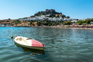 View of sandy beach in Bay of Lindos, with Lindos town and  Acropolis in background (Rhodes, Greece) clipart