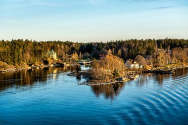 Stockholm takımadalarındaki güzel güneşli bir gün batımında adaların manzarası. İsveç. Su manzarası
