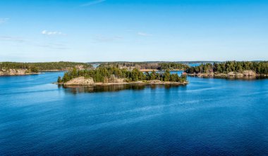 Baltık Denizi 'ndeki Stockholm Takımadaları' nın Rocky sahili. Güneşli bahar akşamları geleneksel evleri var..