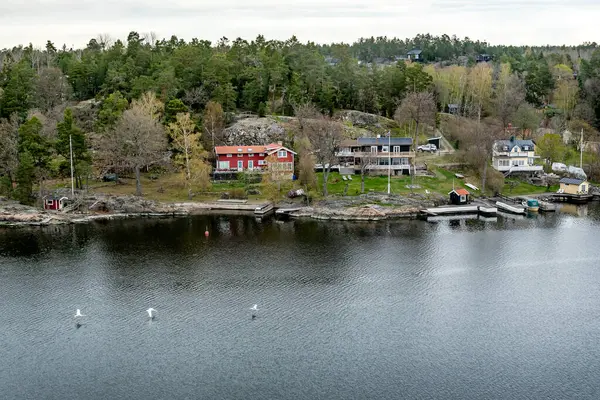 Stockholm 'ün dışındaki İsveç takımadalarında küçük cennet limanı. Sonbahar akşamı güneş lekesi ile aydınlanan güzel bir yansıması var..