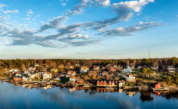 Stockholm 'ün dışındaki İsveç takımadalarında küçük cennet limanı. Sonbahar akşamı güneş lekesi ile aydınlanan güzel bir yansıması var..