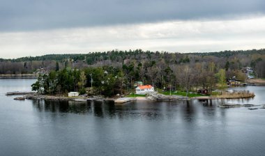 Stockholm 'ün dışındaki İsveç takımadalarında küçük cennet limanı. Sonbahar akşamı güneş lekesi ile aydınlanan güzel bir yansıması var..