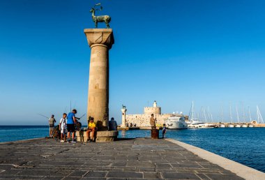 Rodos, Yunanistan. 3 Temmuz 2024: Rhodes 'taki Liman Kapıları ve Deniz Feneri balıkçılar ve turistlerle