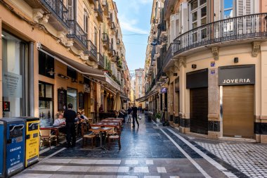 11 Ekim 2024, Malaga, İspanya - Kafeterya terasları ve dükkanları olan Malaga City sokak manzarası