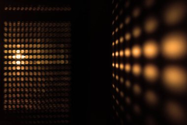 Güneşin perdelerden doğuşu soyut bir etki yaratır. Sabah güneşi pencerenin perdelerinden parlıyor Altın bir desen oluşturuyor