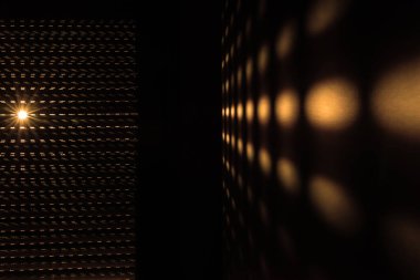 Güneşin perdelerden doğuşu soyut bir etki yaratır. Sabah güneşi pencerenin perdelerinden parlıyor Altın bir desen oluşturuyor