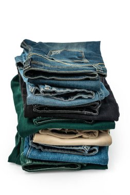 Beyaz arkaplanda izole edilmiş mavi ve renkli kot pantolon, istiflenmiş kot pantolon, geri dönüşüm, kırpma yolu dahil