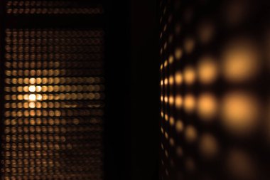 Güneşin perdelerden doğuşu soyut bir etki yaratır. Sabah güneşi pencerenin perdelerinden parlıyor Altın bir desen oluşturuyor