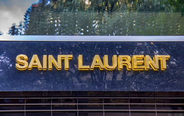 stock image ZURICH, SWITZERLAND - AUGUST 3, 2022: Yves Saint Laurent YSL is a French luxury fashion house founded in 1961. Lighted YSL logo trademark on shop wall at Design District in Zurich, Swiss