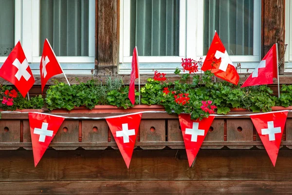 スイスの旗と古い伝統的な木製の窓 ストック画像