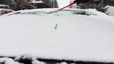 Kışın arabanın ön camını siliyorum.