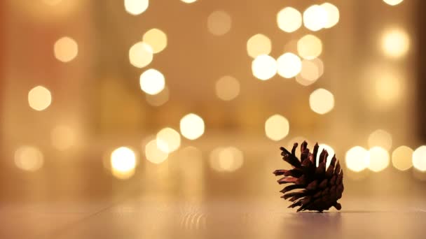 Tannenzapfen Mit Strickmütze Auf Einem Hintergrund Aus Weihnachtslicht — Stockvideo