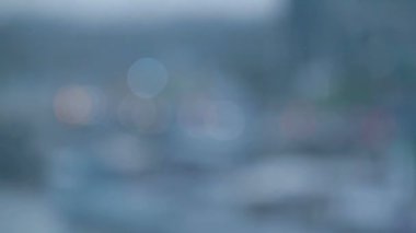 Bardakta yağmur damlası. Camdaki yağmur damlaları ve modern gökdelenlerin manzarası.