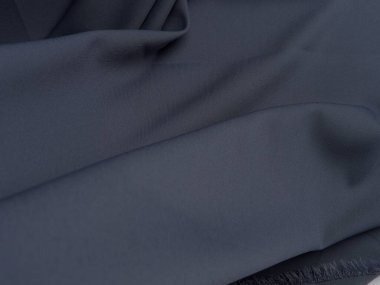 Koyu gri kumaş güzel kıvrımlar halinde yatar. Koyu gri kumaşın yüksek kaliteli dokusu.