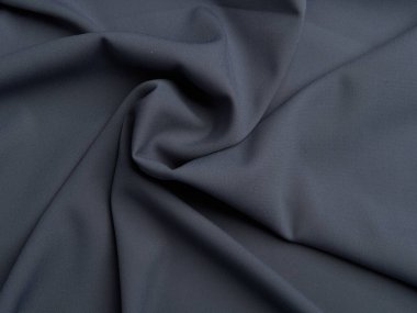 Koyu gri kumaş güzel kıvrımlar halinde yatar. Koyu gri kumaşın yüksek kaliteli dokusu.