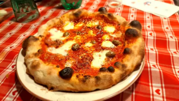 Esmer arka planda baharatlı, domatesli ve peynirli Napoli pizzası. Mozzarella soslu pizza, domates sosu, kalın hamurlu ıspanak..