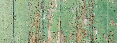 Arkaplan, soyulmuş boyaların soyulduğu soyut desenli yeşil tahta levhalardan oluşmaktadır.