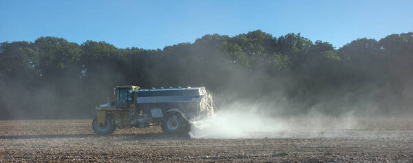 blue truck spreads lime on agricultural field in france near dijon in saone valley