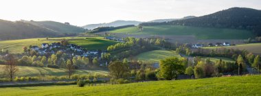 light of early sunrise on village and countryside landscape of westerrnboedefeld in german sauerland in spring