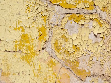 Fransa 'da bir yerde, duvardaki kırık sarı boyaya yakın plan.