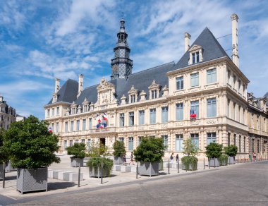 Reims, Fransa, 18 Temmuz 2024: İnsanlar Fransa 'nın Reims şehrindeki Hotel de ville' in önünde mavi gökyüzünün altında yürüyorlar.
