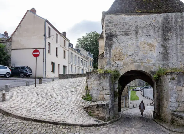 stock image laon, france, 21 july 2024: man under porte d'ardon of old medieval fortified city of Laon in the north of france with view over surrounding landscape