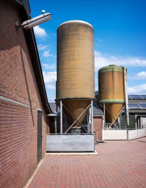 two food silo's on organic pig farm in the netherlands clipart