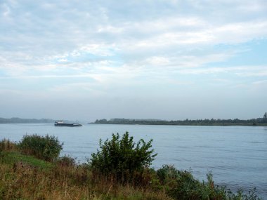 lonely barge on north sea canal sailing towards amsterdam in morning mist clipart