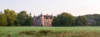 old manor slangenburg near dutch town of doetinchem and surrounding green landscape clipart